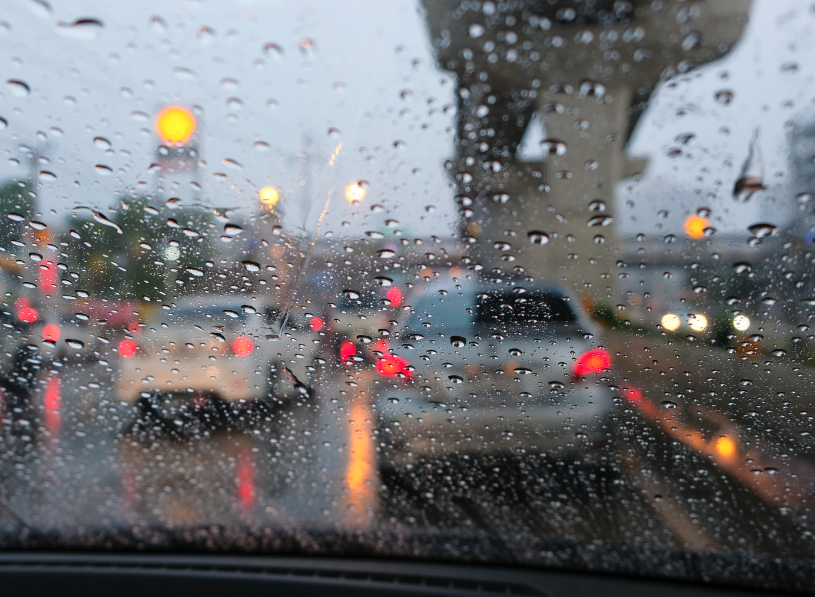 Rain-covered windshield looking out at Fort Smith traffic on a stormy day